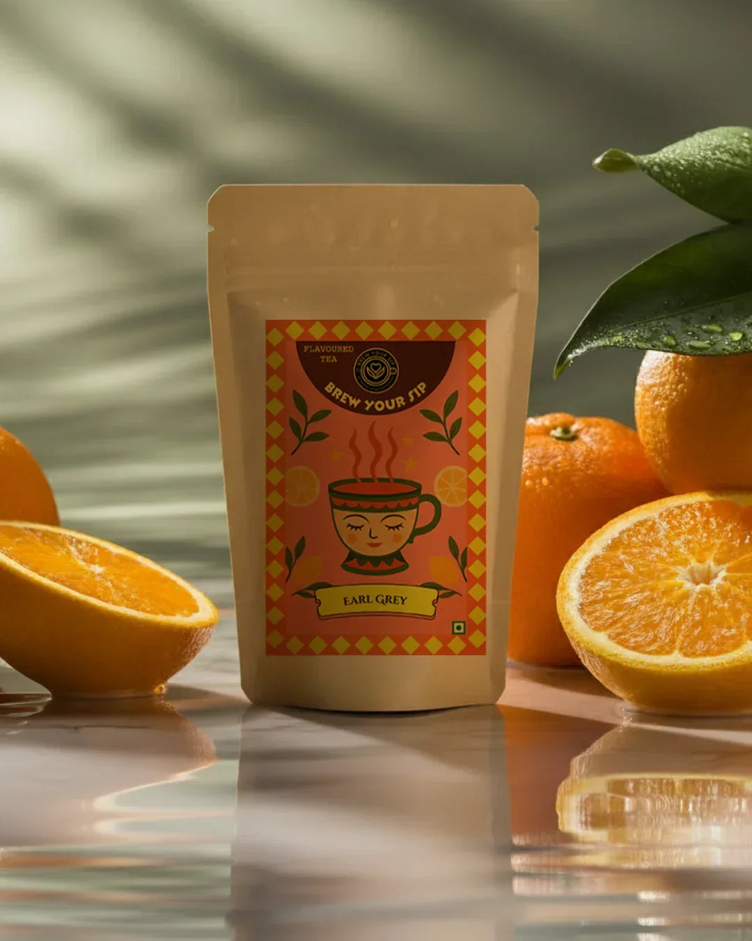 Packaged tea with orange slices on a reflective surface