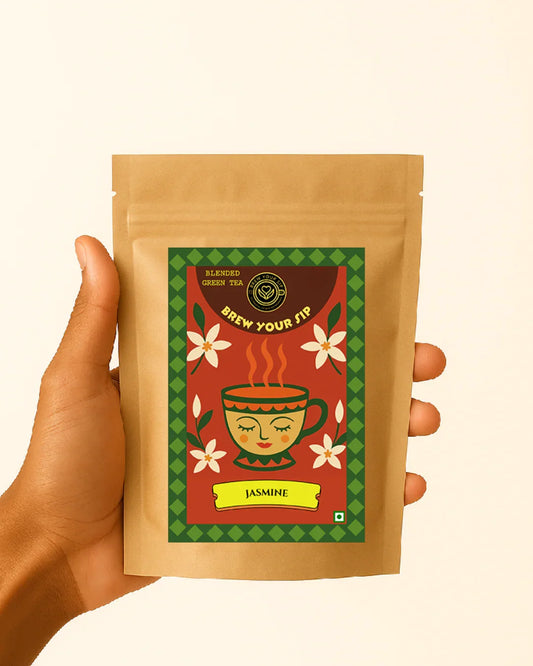 Hand holding a brown tea package with a colorful label on a beige background