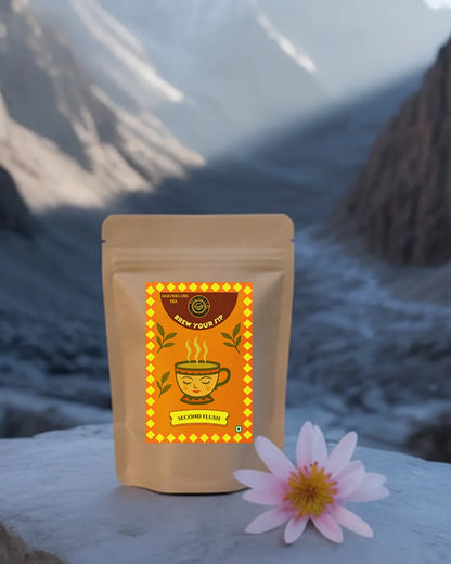 Brew Your Sip Second Flush tea pack kept on a big stone and a mountain can be seen behind the tea pack 
