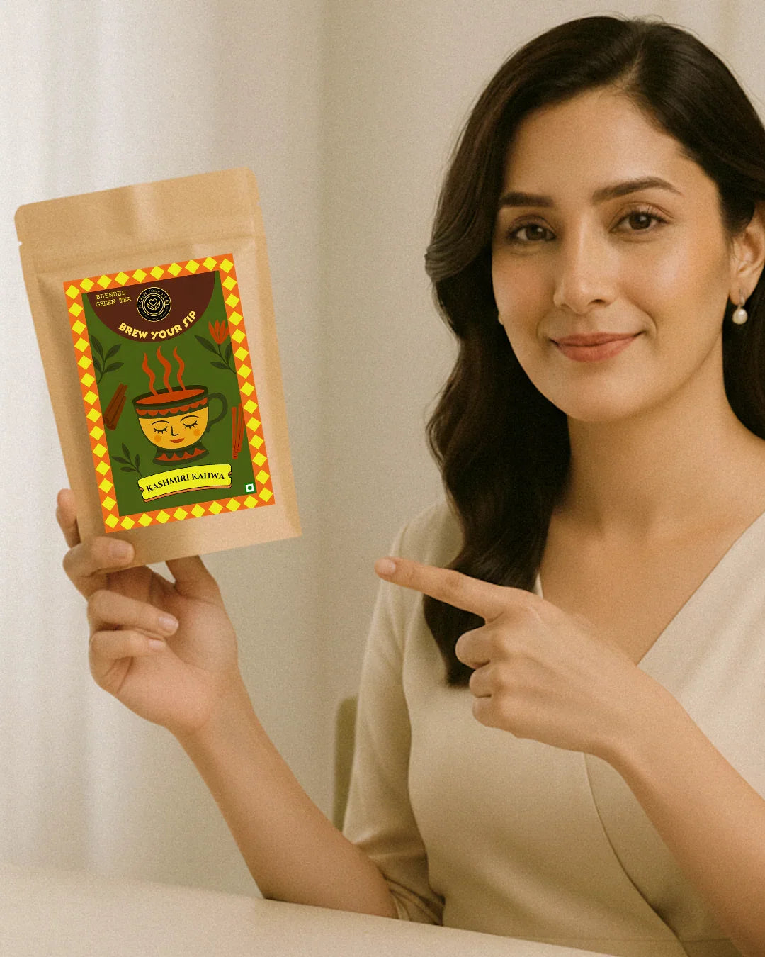 Woman holding and pointing to a tea package with a decorative label.