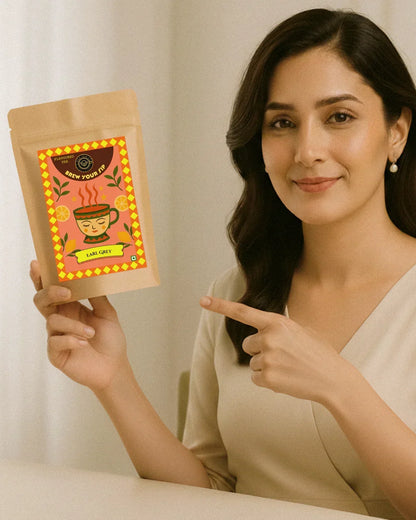 Hand holding a brown tea package with a colorful label on a beige background