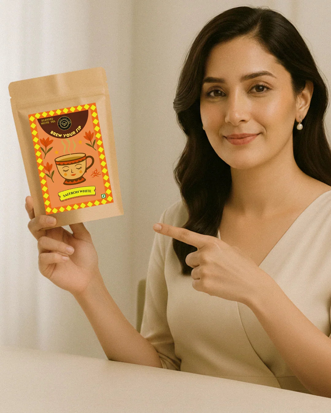 Woman holding and pointing to a package of Brew Your Sip's White Tea