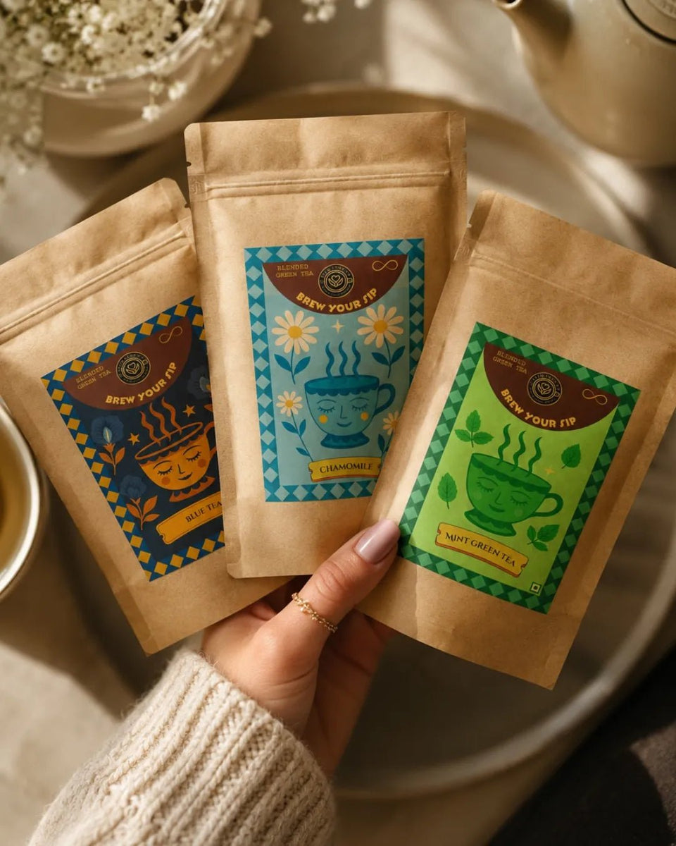 Hands holding three Brew Your Sip mint, chamomile and blue pea sampler pouches